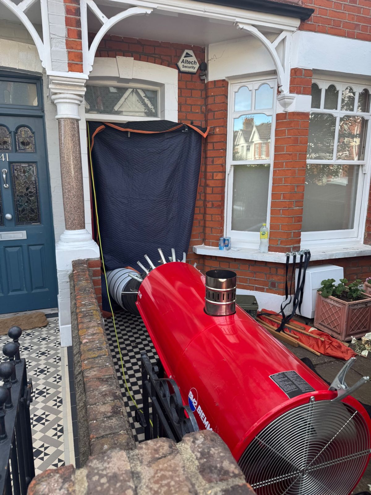 Industrial heater and sealed doorway curtain set up outside a Victorian terrace ready for bed bug heat treatment